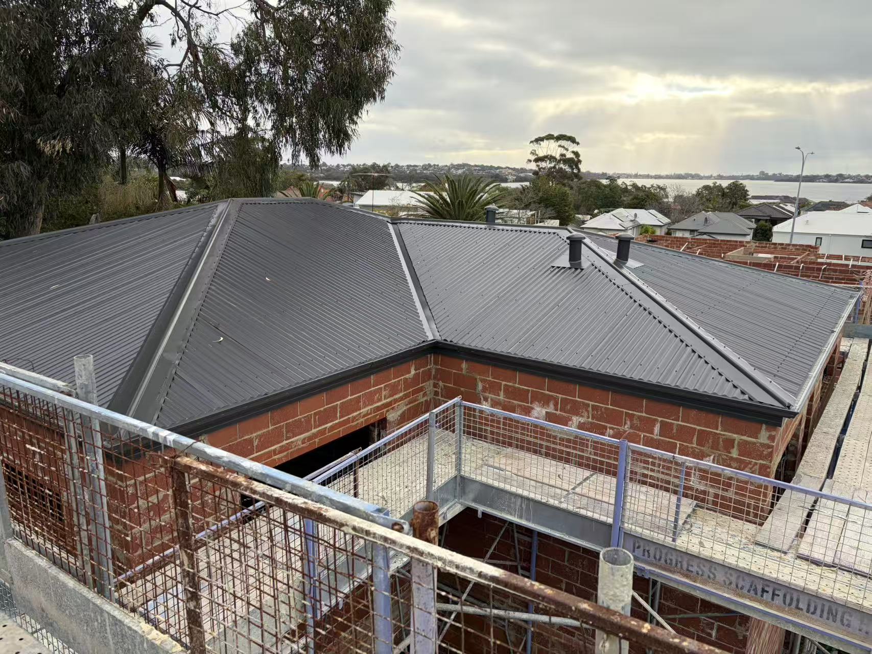 New charcoal Colorbond roof on a double-storey brick home